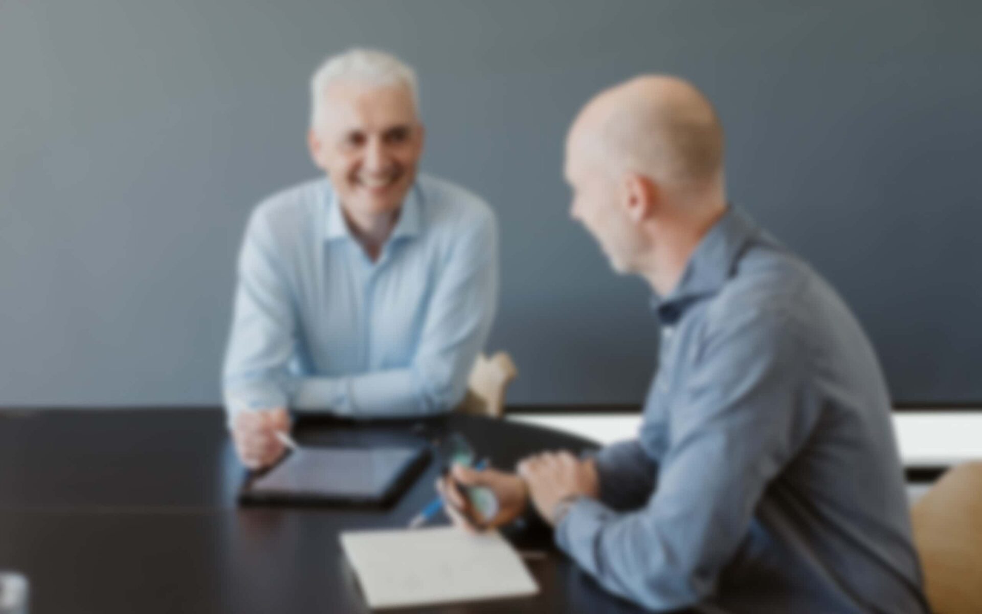 Chris Cooper in discussion with colleague during business meeting.